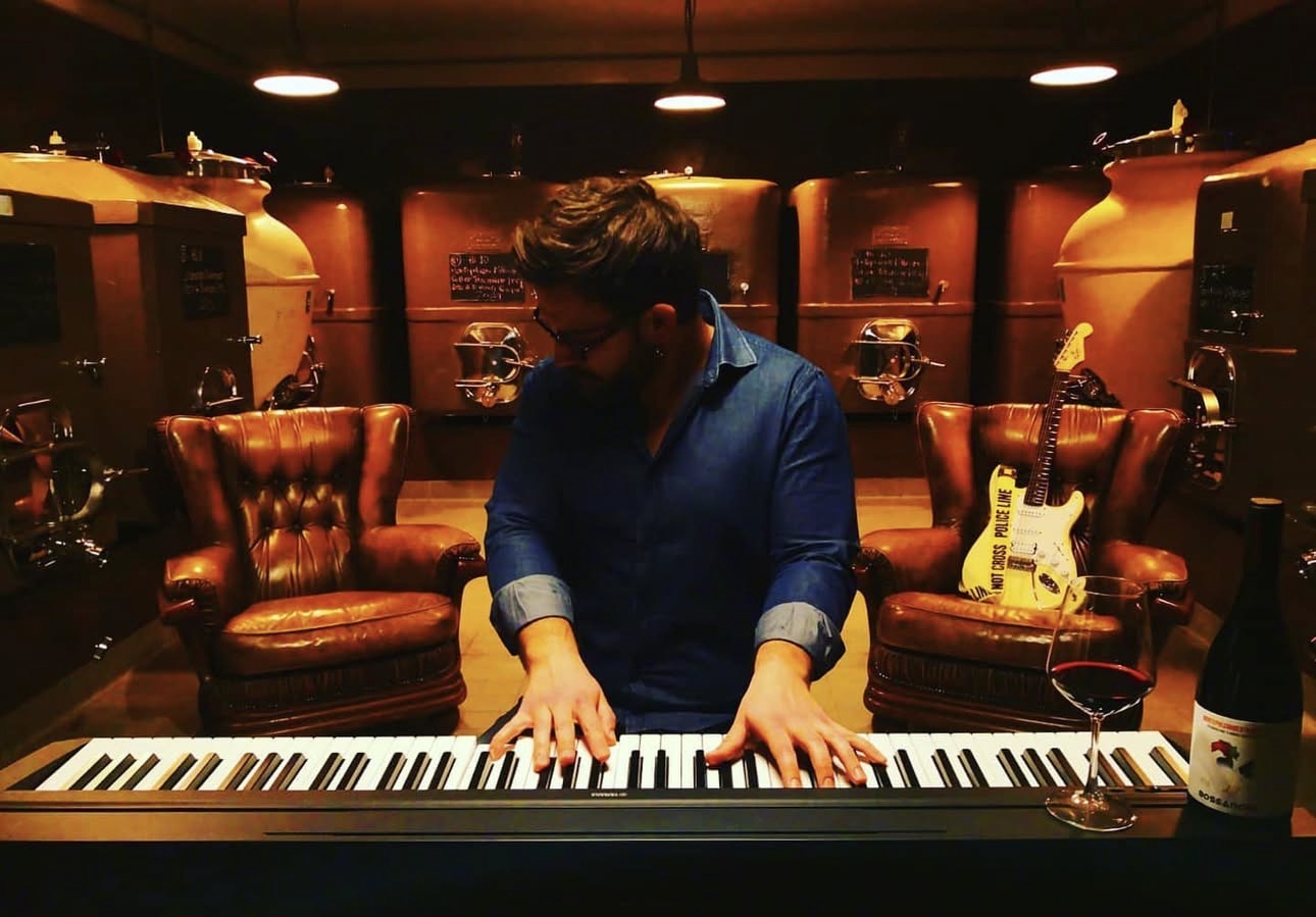 Andrea Quaglia playing piano in the Bossanova cellar among amphorae